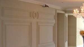 A hallway with a polished floor, a white door with a number, and a chandelier. - Las Piedras Beach Experience I (Mar del Plata)