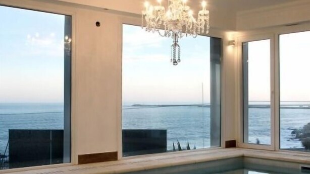 A large indoor swimming pool with a view of the sea, a chandelier, and a modern design. - Las Piedras Beach Experience I (Mar del Plata)