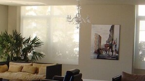 Un amplio salón con un conjunto de sofás, una mesa de centro y una araña.