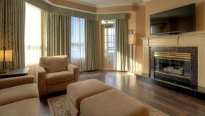 Una sala de estar con chimenea, televisor y sofá.