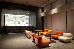 Un espacio lounge moderno con asientos y una barra.