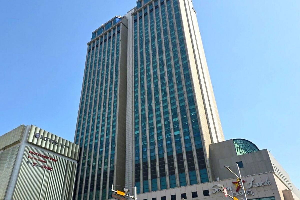 A tall, modern building with a glass facade and a prominent casino sign at the base.