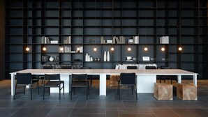 A modern conference room with a long table, black chairs, and a dark bookshelf with books and decorative items. - Shilla Stay Busan Haeundae (Busan)
