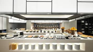 A modern buffet setup with various food items and dishes arranged on a long counter.