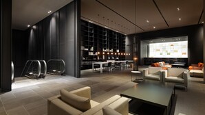 A modern lobby with seating areas, a large bookshelf, and a bar area. - Shilla Stay Busan Haeundae (Busan)