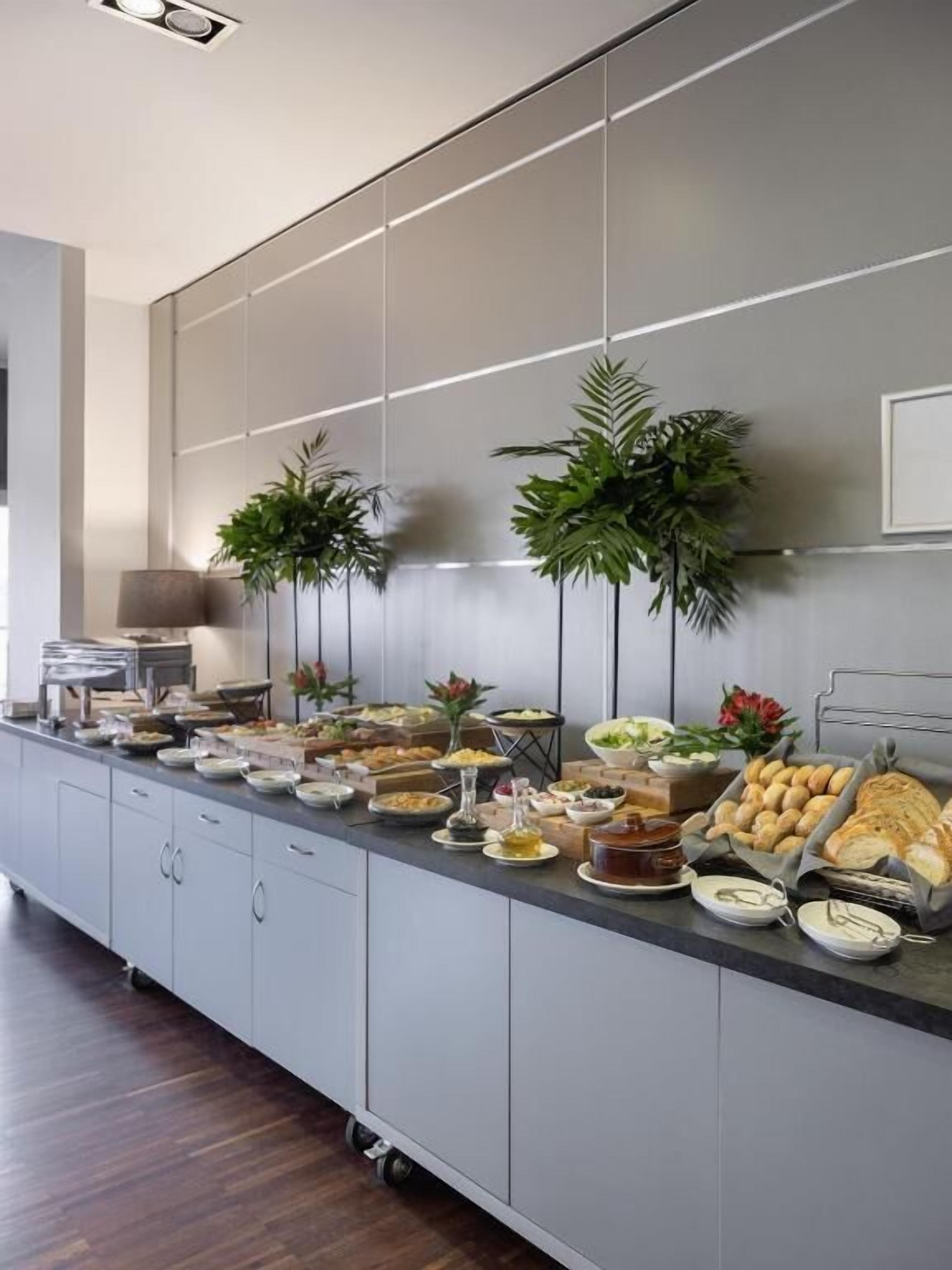 A buffet setup with various food items and plants.