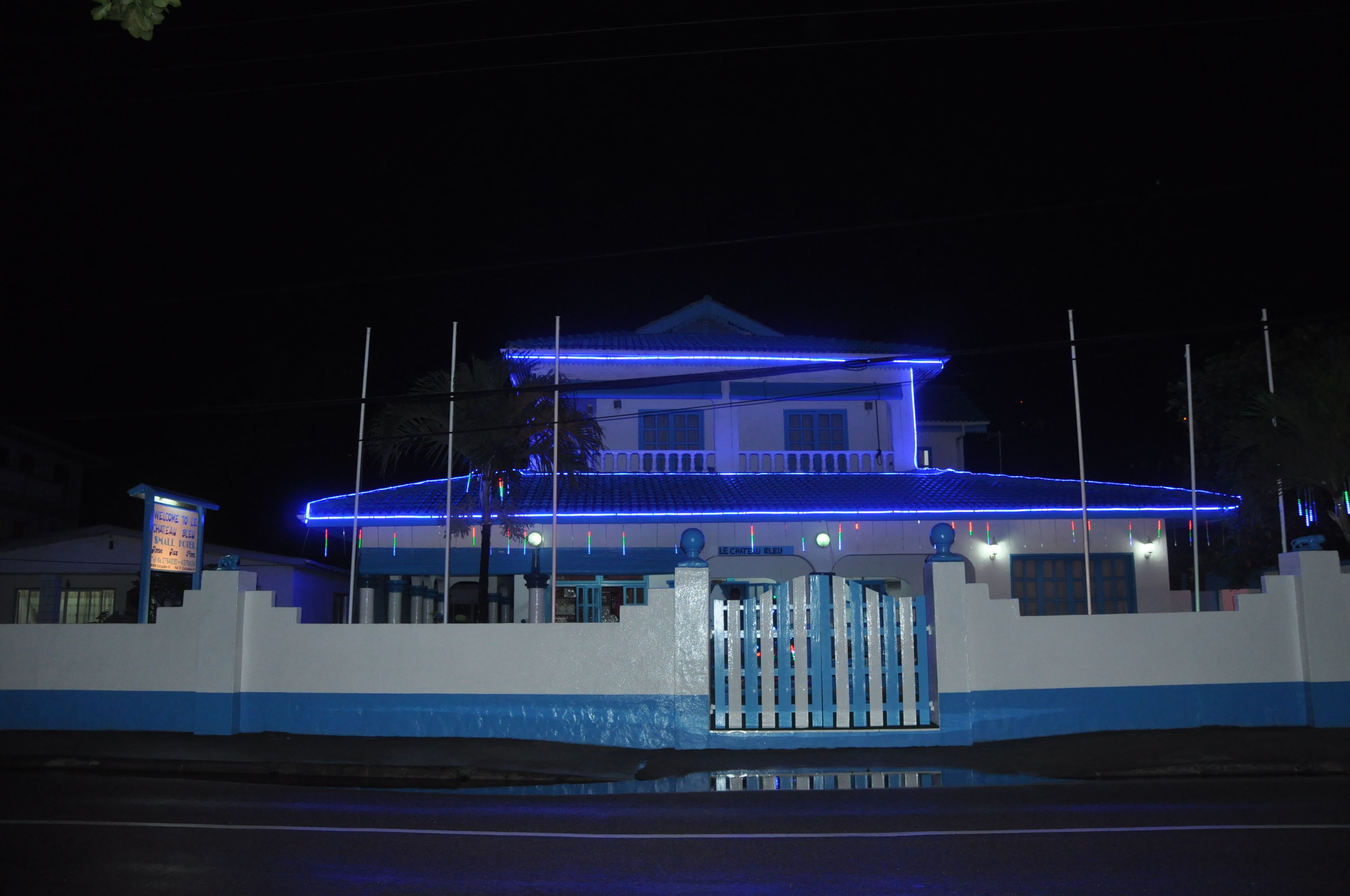A building with a blue-lit roof and a gated entrance.