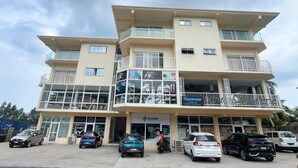 A multi-story building with a ground floor featuring a café and restaurant named "Champion's Sports Bar Café & Restaurant." - Le Chateau Bleu (Mahé Island)