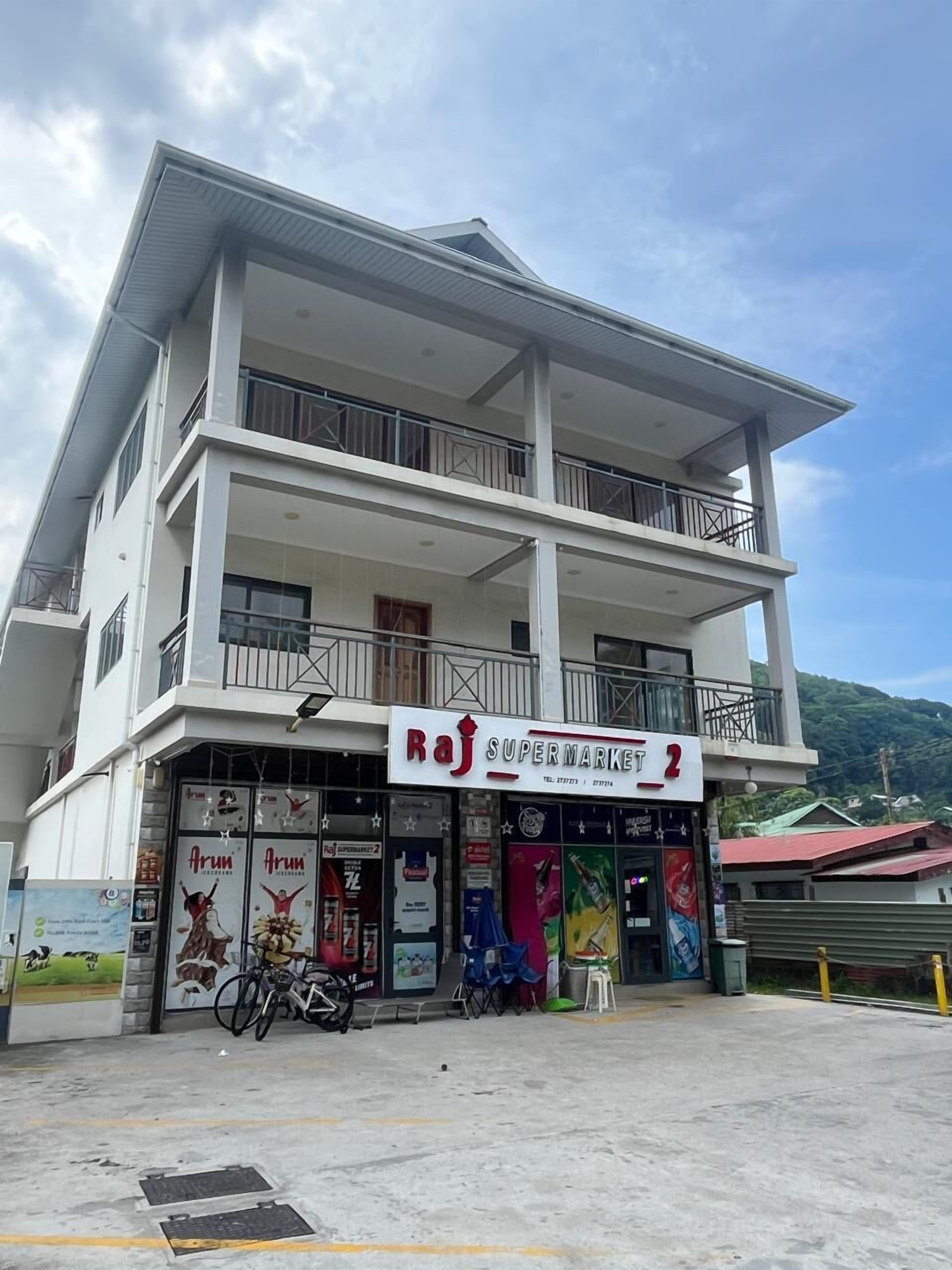 Un edificio de dos pisos con un letrero que dice Raj Supermarket 2.