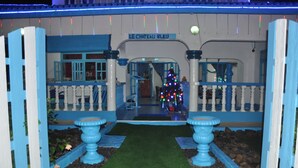 A model of a house with a sign reading "LE CHATEAU BLEU" and a decorated Christmas tree. - Le Chateau Bleu (Mahé Island)