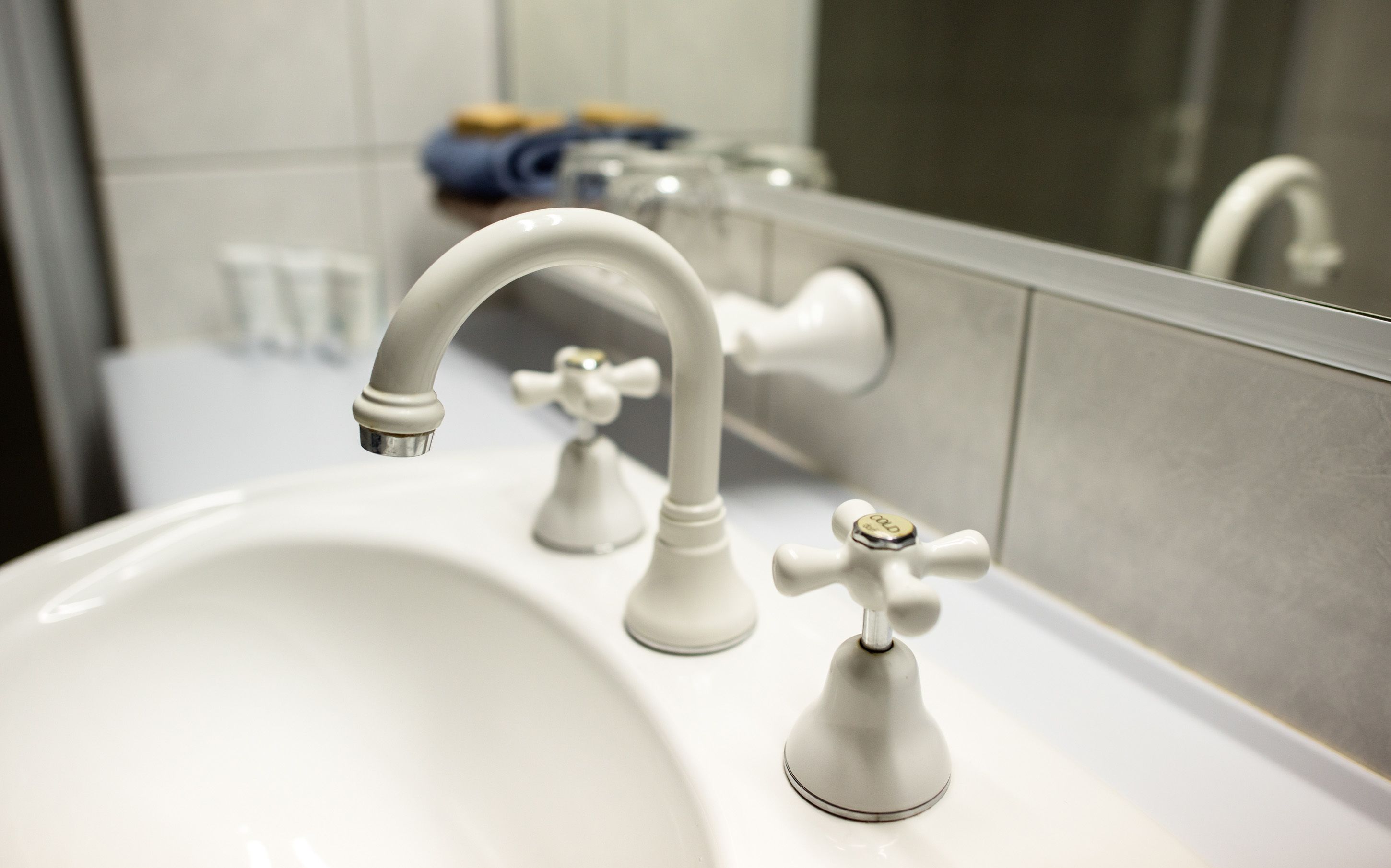 A bathroom sink with a modern faucet and a mirror reflecting the sink and faucet.