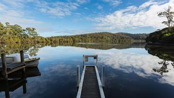 A dock extending into calm water with a boat moored at the end.