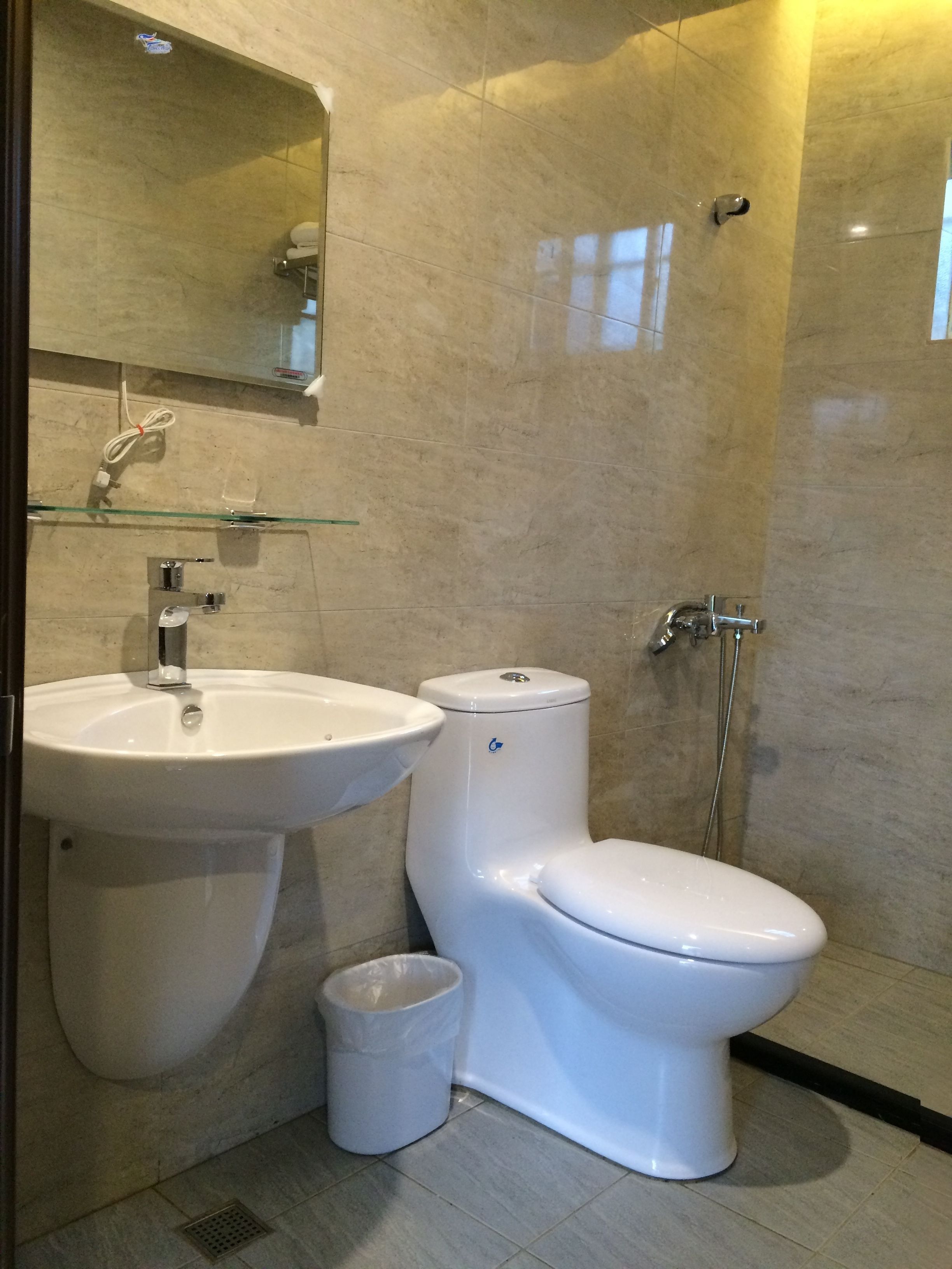 A modern bathroom with a sink, toilet, and shower.