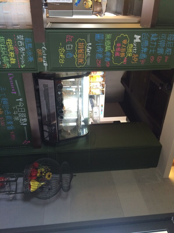 A restaurant with green walls and a black counter. There are colorful menus and a small display case with items. - True Love Villa (Hengchun)