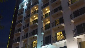 A multi-story hotel with balconies, a sign reading "HOTEL ROOMZ HOTEL", and a person standing at the entrance. - RoomZ Hotel (Seria)
