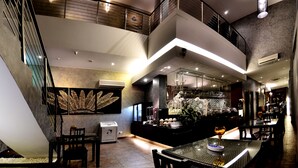 A modern interior with a dining area, a staircase, and a kitchen. - RoomZ Hotel (Seria)