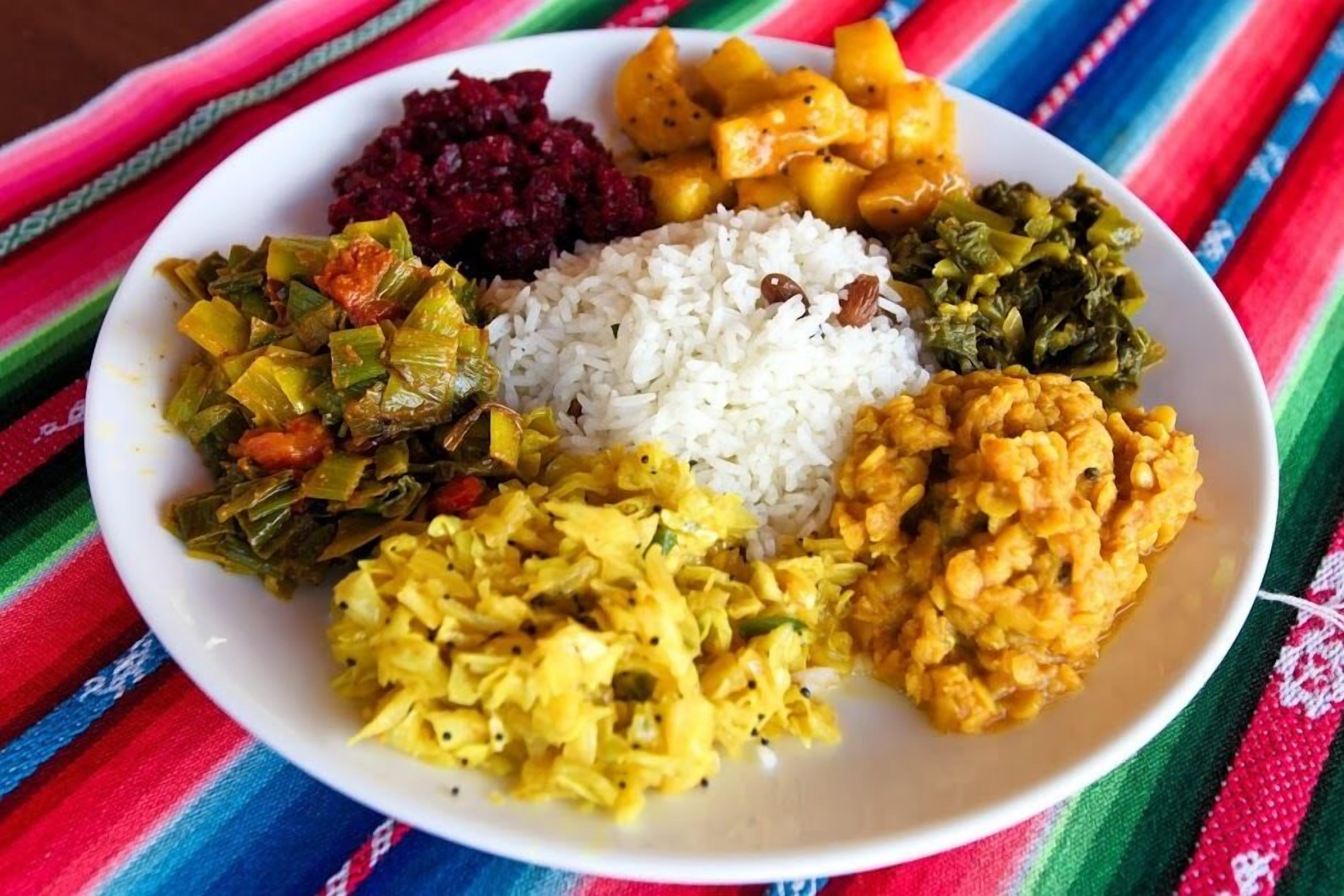 A plate of food with rice, vegetables, and a side dish.