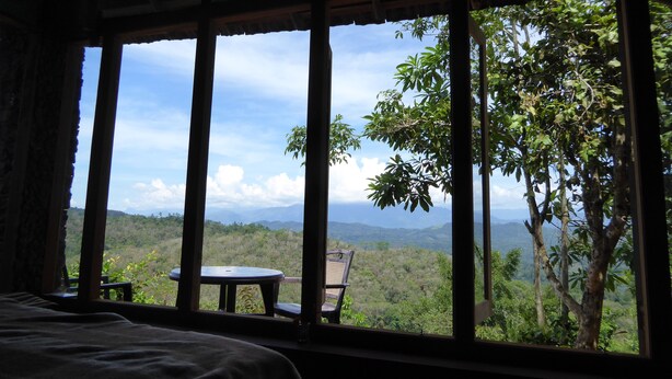 A room with a large window overlooking a lush landscape. - Kurulu Estate (Rakwana)