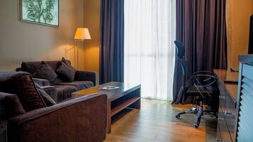 Suite, 1 cama King size | Área de sala de estar | Televisión LCD de 32 pulgadas con canales vía satélite y televisión