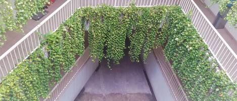A covered outdoor area with a concrete floor and a white railing.
