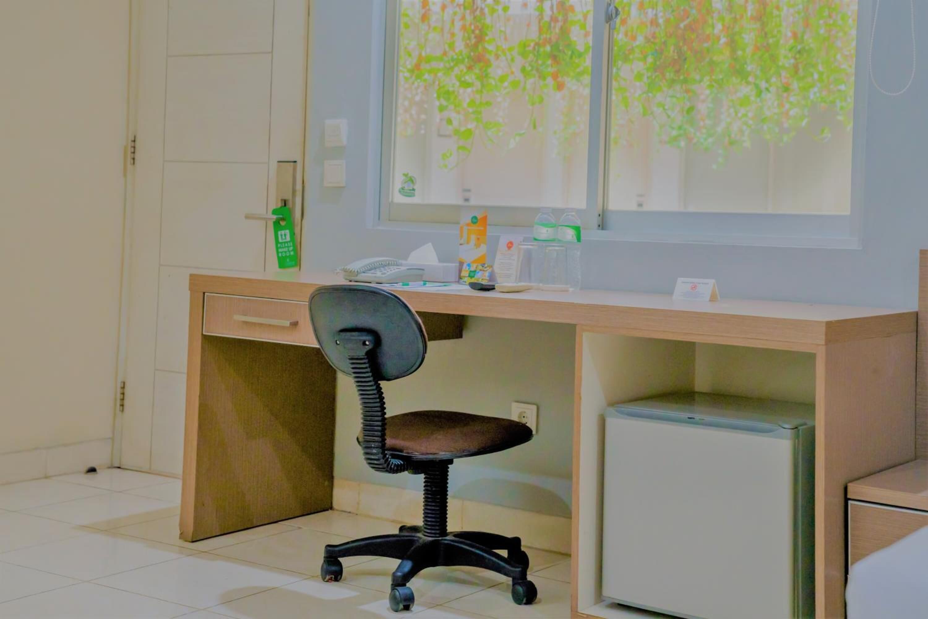 A small office space with a desk, chair, and a mini-fridge.