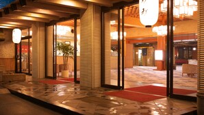 A hotel entrance with a wet floor, red carpet, and traditional Japanese lanterns. - Moriaki Ryokan (Shibukawa)