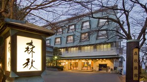 A traditional Japanese building with a well-lit entrance and signage in Japanese. - Moriaki Ryokan (Shibukawa)