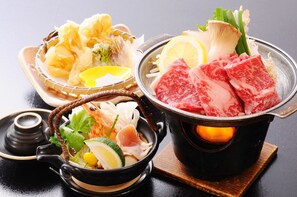 A hot pot with various ingredients like meat, vegetables, and mushrooms. - Moriaki Ryokan (Shibukawa)