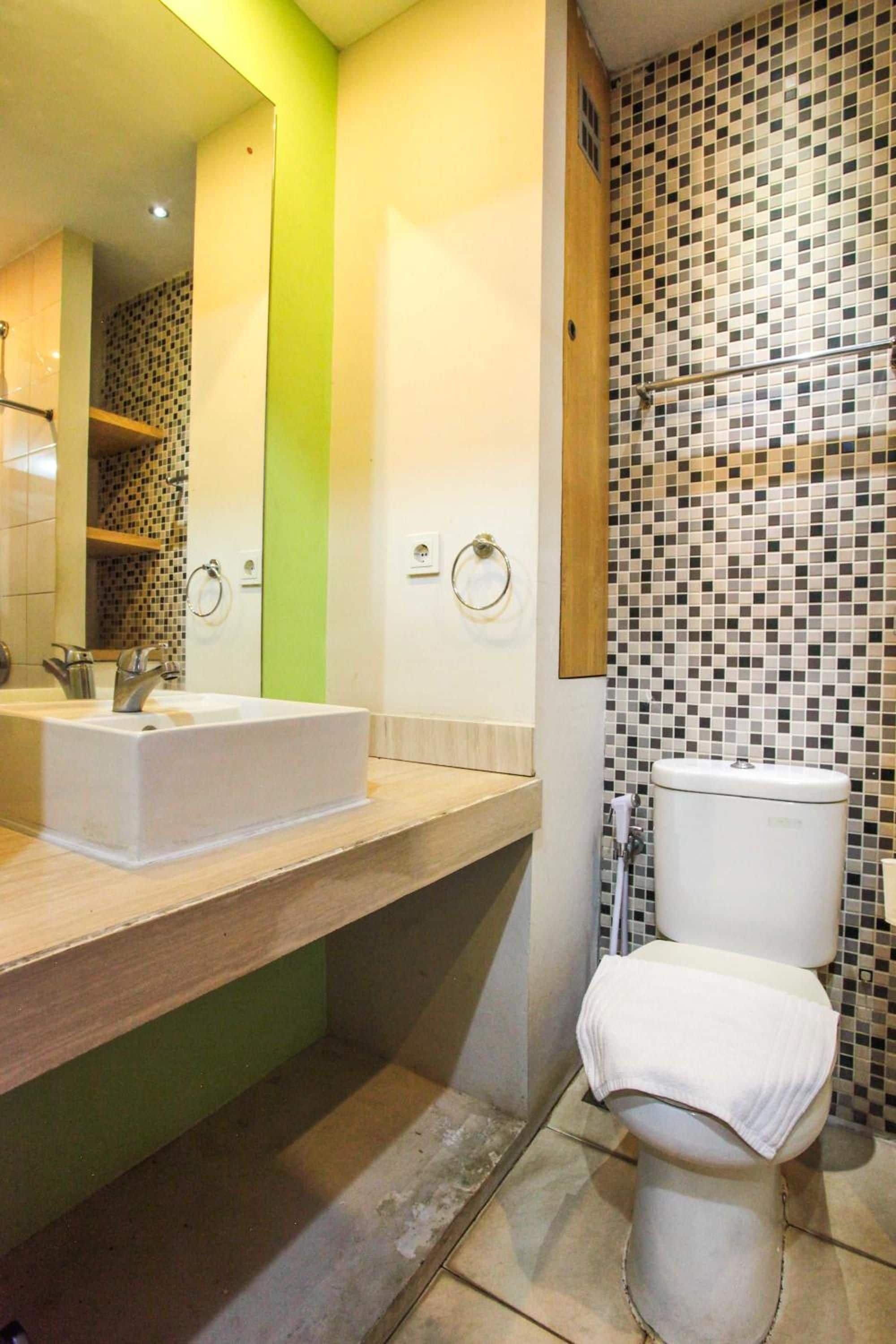 Un baño con lavamanos blanco, inodoro y zona de ducha.
