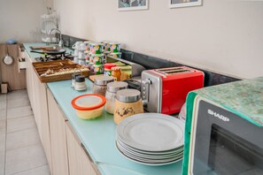 Una encimera de cocina con diversos alimentos, un tostador y un microondas Sharp.