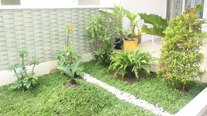 A garden with various potted plants and a white gravel path. - Sierra Villa Malang (Malang)