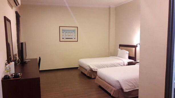 A hotel room with two beds, a desk with a computer, and a framed picture on the wall. - Cheng Ho Residence (Malacca City)
