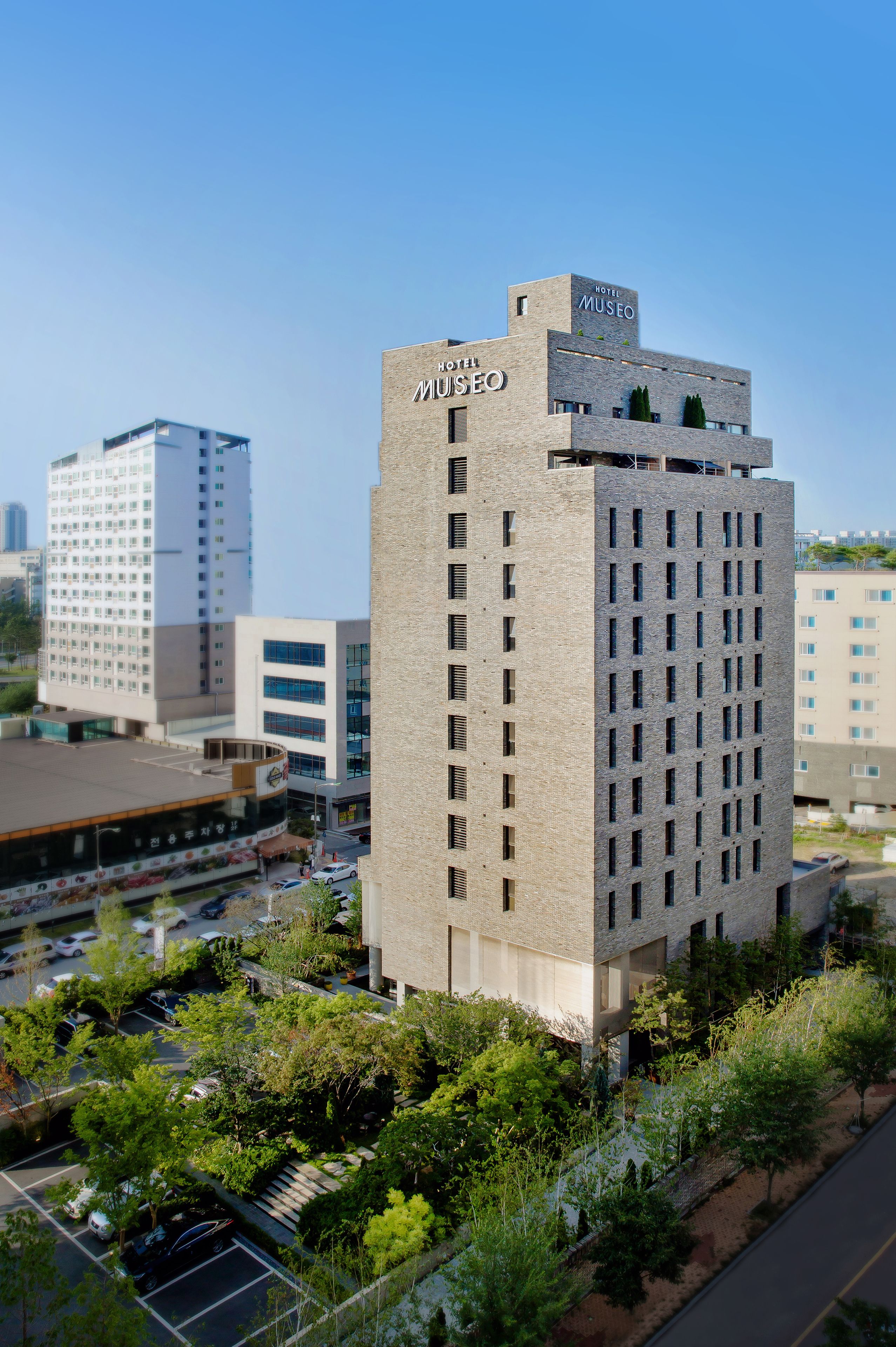 A hotel with a modern design, featuring a prominent 'Hotel Museo' sign on the top.
