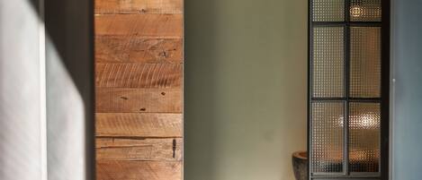 A wooden wall and a glass door with a frosted pattern.