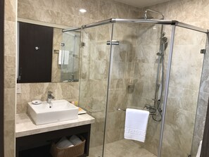 A modern bathroom with a glass-enclosed shower, a white sink, and a mirror above the sink. - ML Hotel (Chiayi City)