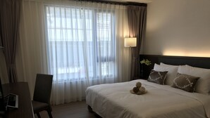 Ein Hotelzimmer mit einem großen Bett, einem Schreibtisch und einem Stuhl.
