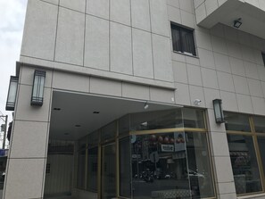 A building with a modern facade, large glass windows, and a visible storefront with signage. - ML Hotel (Chiayi City)