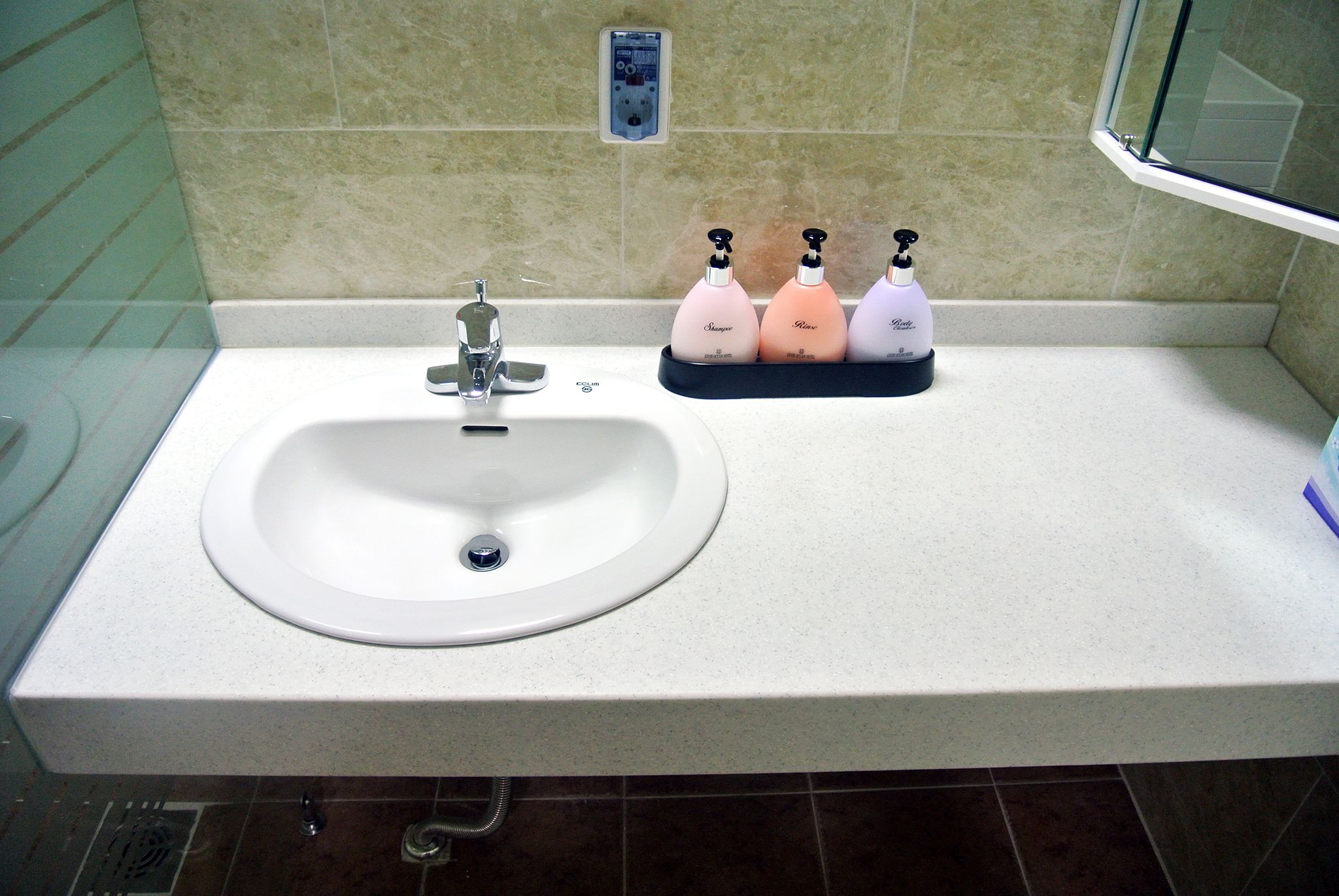 A bathroom sink with a faucet, a soap dispenser, and a mirror.