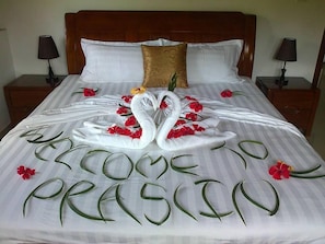 A bed with a decorative swan and floral arrangement, and the text "WELCOME TO PRASIN". - Lone Self Catering Apartment (Praslin Island)