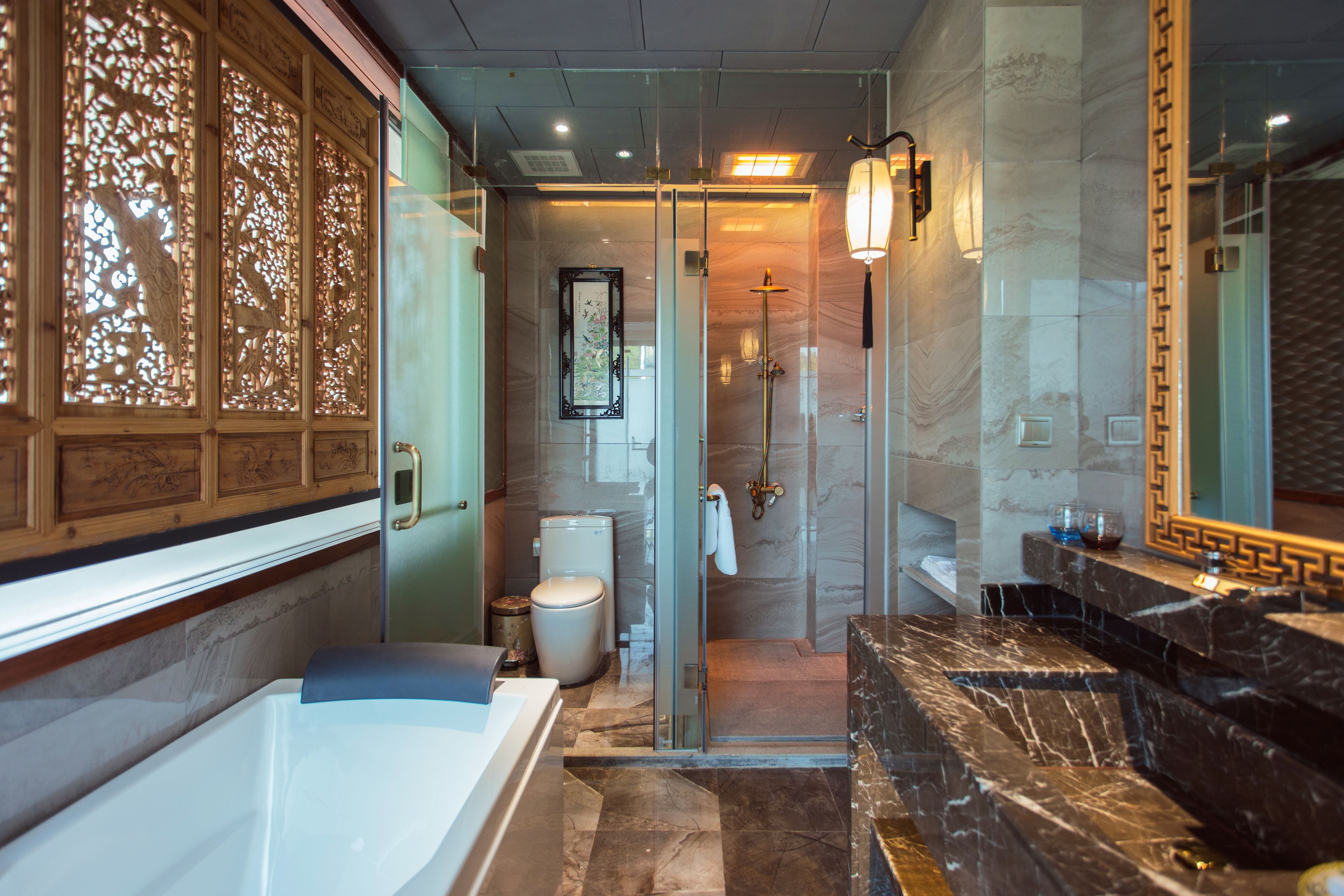 A modern bathroom with a bathtub, a glass shower enclosure, and a marble vanity.