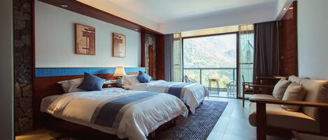 Habitación de hotel con dos camas, un balcón con una silla y un ventanal grande.