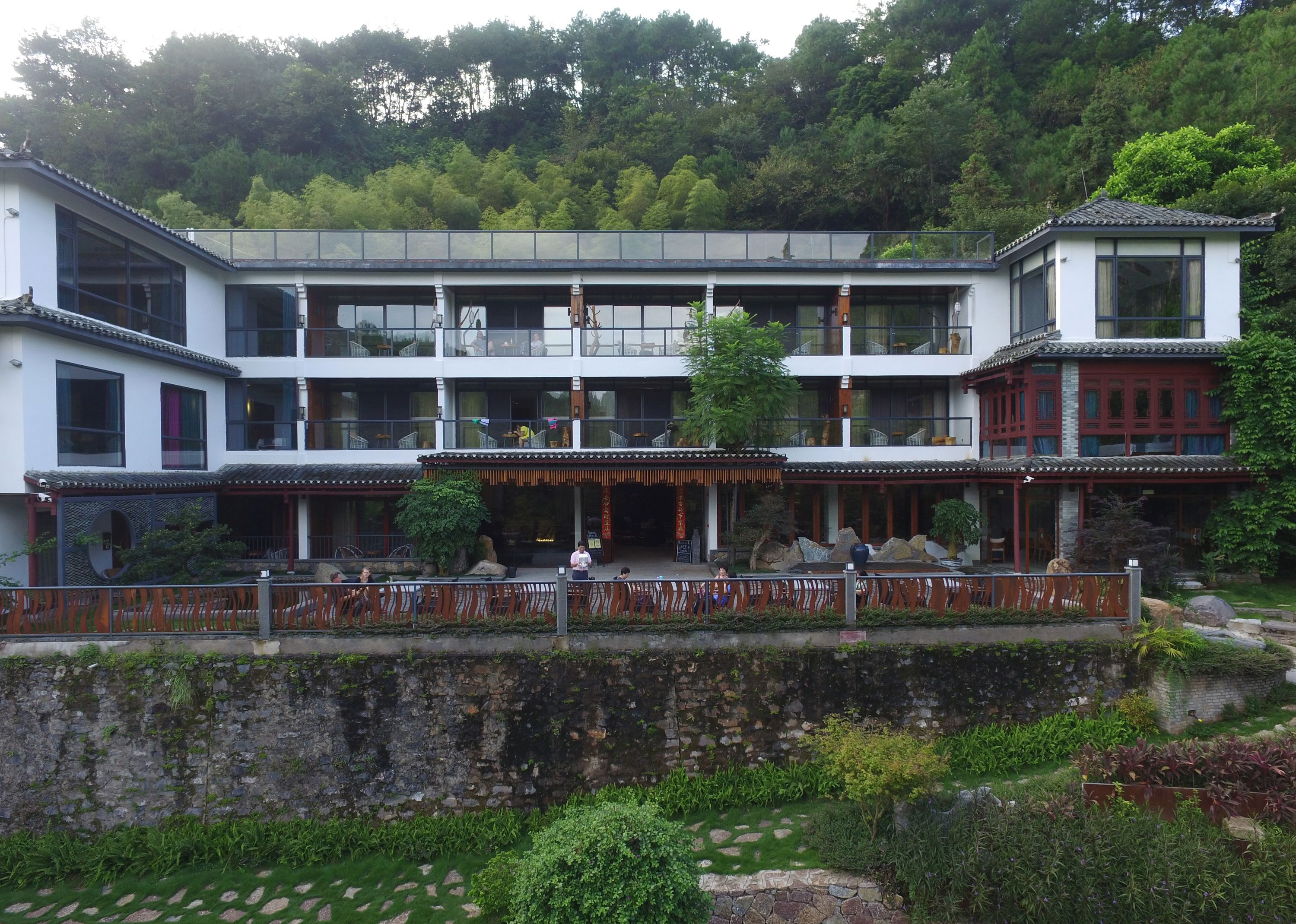 Un edificio de estilo tradicional con varios pisos, ventanas amplias y una pared de piedra frontal.