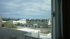 Vista desde una ventana que da a una zona residencial con varias casas y una calle.