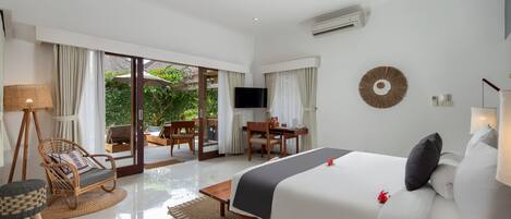 A hotel room with a bed, a desk, a chair, a television, and a view of the outdoors.