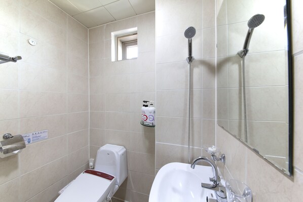 A bathroom with a toilet, a sink, a mirror, and a shower. - K- Grand Hostel Dongdaemun (Seoul)