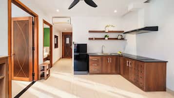 Una cocina moderna con gabinetes de madera, una encimera negra y un ventilador de techo.