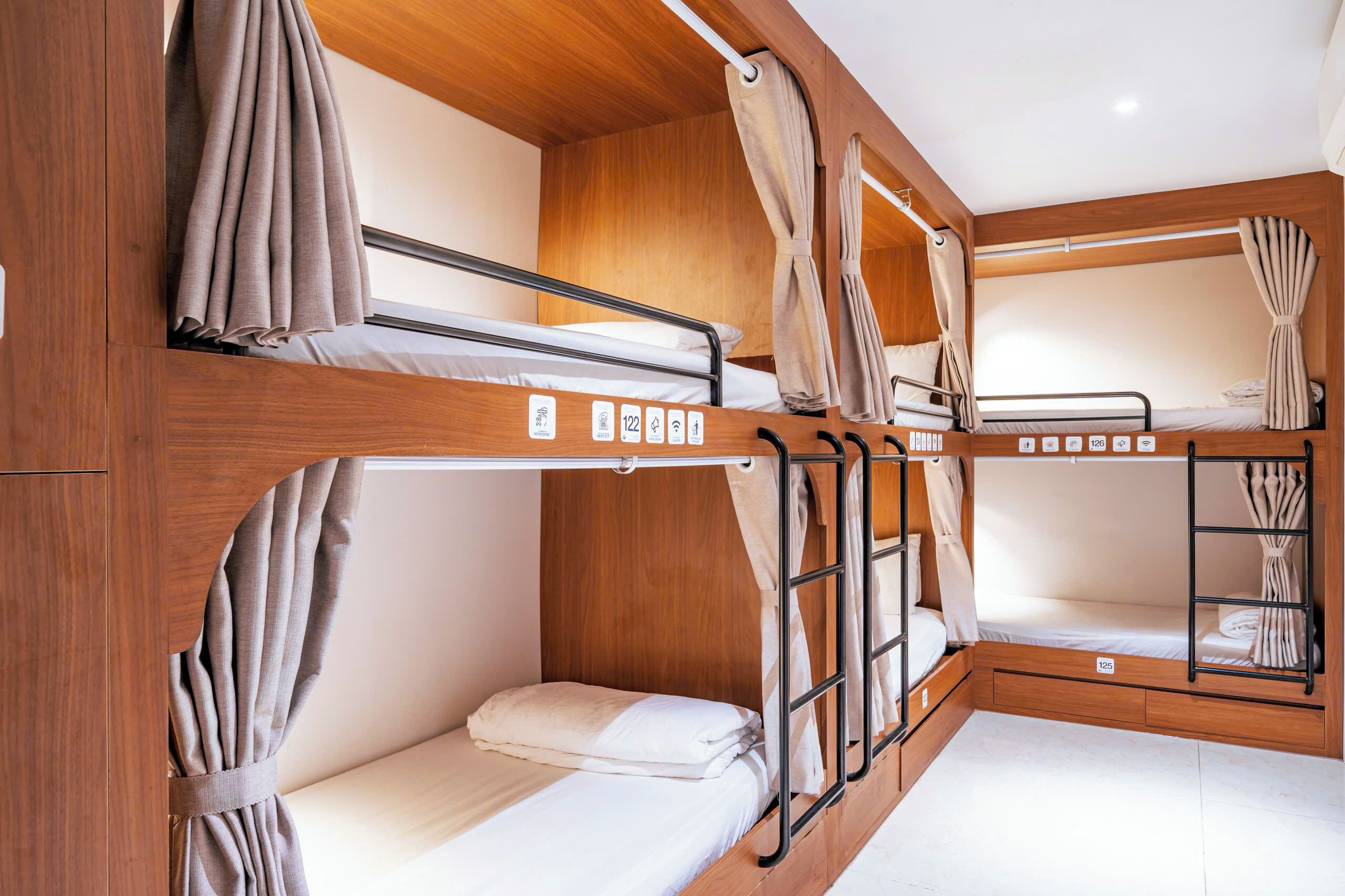 A bunk bed room with wooden walls and curtains.
