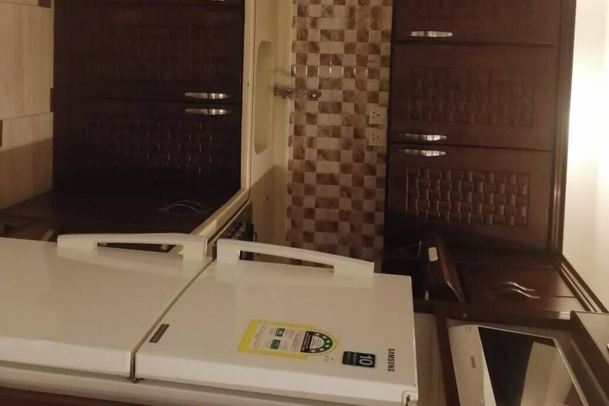 Eine kompakte Küche mit integrierter Waschmaschine, Mikrowelle und Kühlschrank.