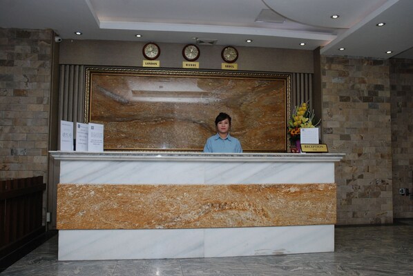 A reception desk with clocks indicating London, Hanoi, and Seoul times. - Dream Gold Hotel I (Hanoi)