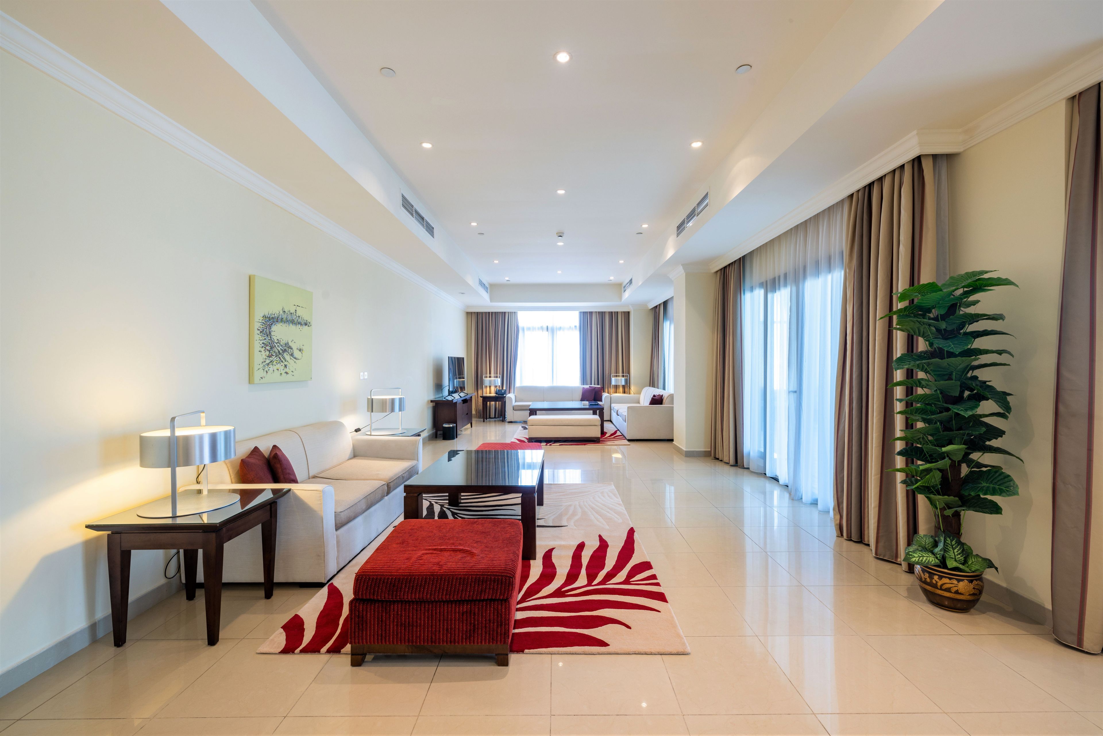 A spacious living area with a sofa, a coffee table, and a red patterned rug.